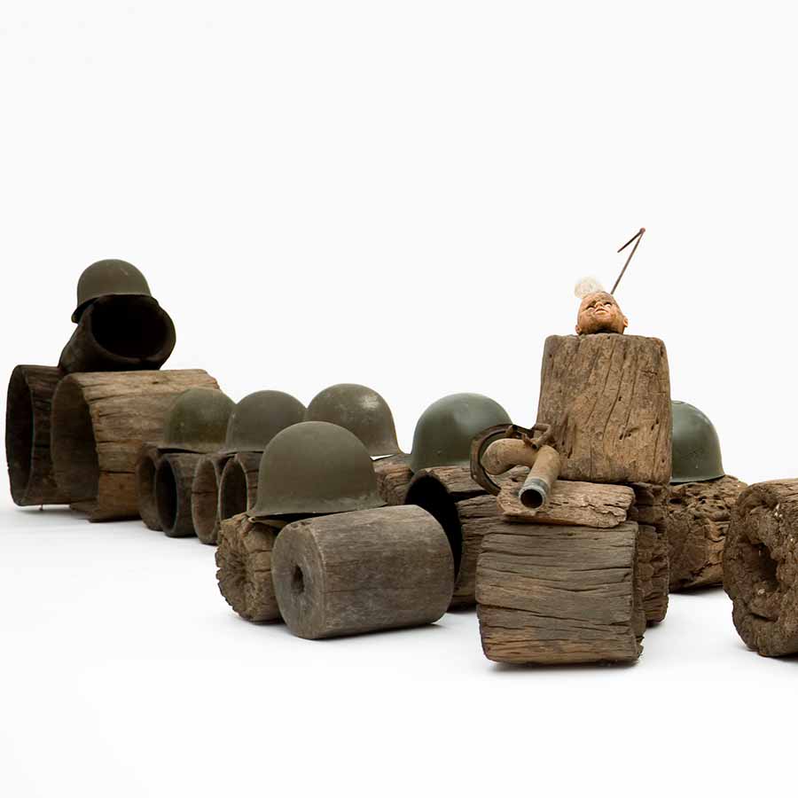 Gérard Quenum, Mort au dictateur. Vive la dictature! (Death to the Dictator. Long Live Dictatorship!), 2012. Wood, helmets, metal pipe, antenna and plastic doll, 75 x 637 x 105 cm.